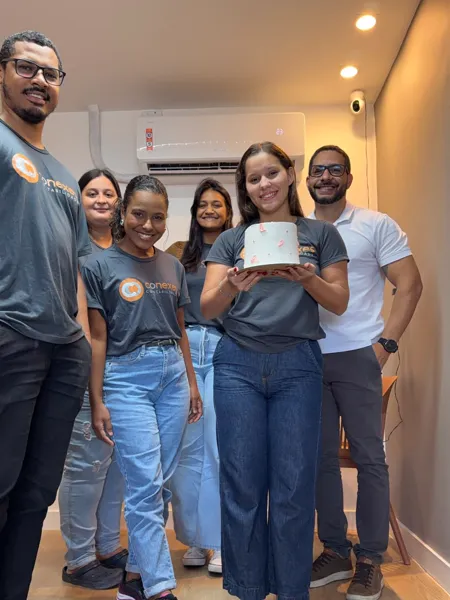 Equipe da Conexes reunida no escritório, todos com a camiseta da empresa